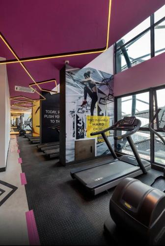 a gym with several treadmills and a painting on the wall at Arte Plus Ampang KLCC City in Kuala Lumpur