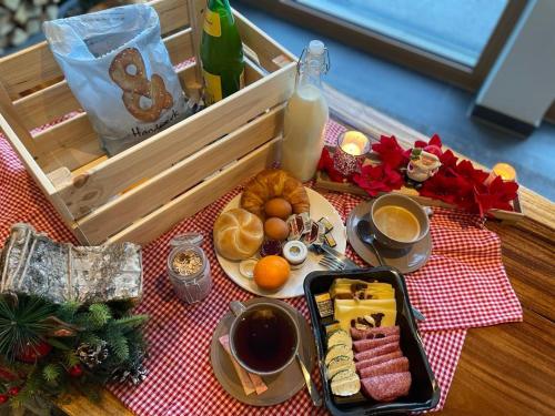 un plateau de petit-déjeuner sur une table avec un plateau de nourriture dans l'établissement Glacier View, à Kaprun