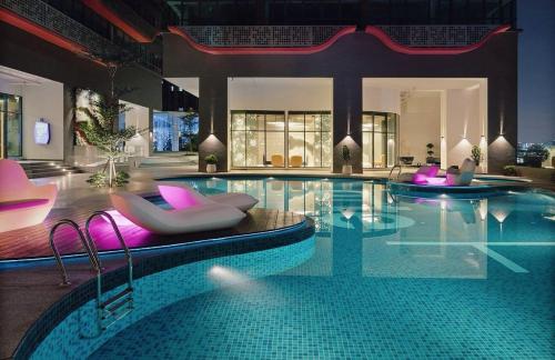 une grande piscine avec des chaises et une piscine dans l'établissement Arte Plus Ampang KLCC City, à Kuala Lumpur