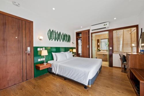 a bedroom with a bed and a desk and a kitchen at Classic Hotel Hanoi in Hanoi