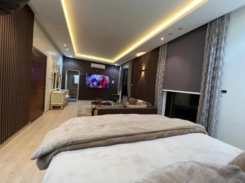 1 dormitorio con 1 cama grande y TV de pantalla plana en شقه فاخرة بالنرجس بالقرب من المطار en Riad