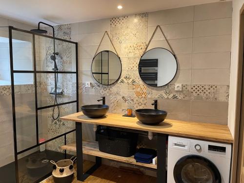 bagno con 2 lavandini e lavatrice di MAISON DE VILLAGE a Chambon-le-Château
