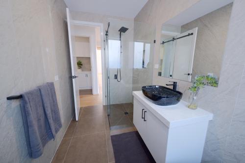 y baño con lavabo negro y ducha. en Modern Spacious Coastal Villa, en Ocean Grove