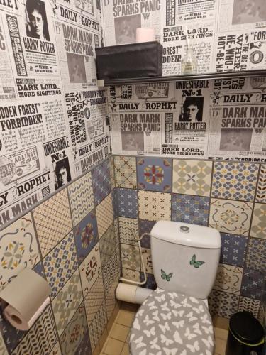 a bathroom with a toilet with lots of newspapers at Sérénité au cœur de ville in Saint-Dizier