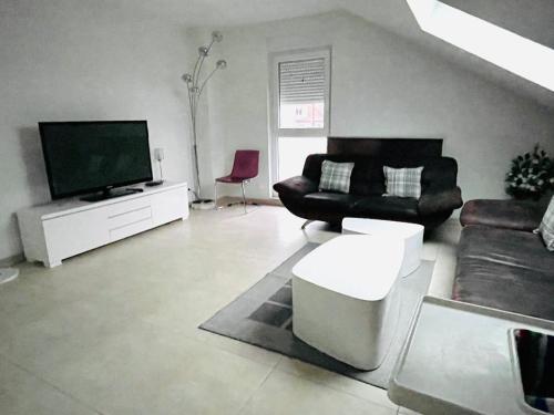 a living room with a couch and a tv at Appartement Bes,, Attique neuf avec confort in Wittenheim