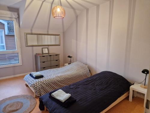 a bedroom with two beds and a window at Sérénité au cœur de ville in Saint-Dizier