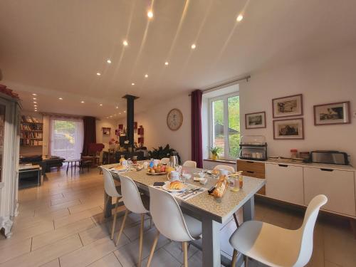 eine Küche und ein Esszimmer mit einem Tisch und Stühlen in der Unterkunft Chambre d'hôte Le Clos d'Audio à Riols in Riols