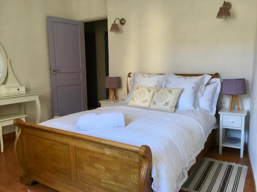 een slaapkamer met een groot bed met witte lakens en kussens bij La maison Vigne Vierge in Lagrasse