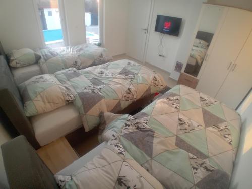 a room with three beds and a mirror at Villa Green in Mostar