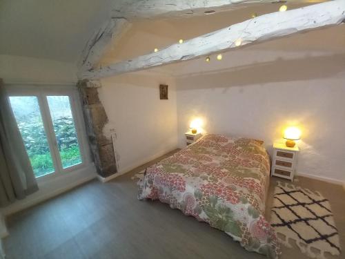 una camera con un letto e due lampade su due tavoli di La Longère du Moulin a Laburgade