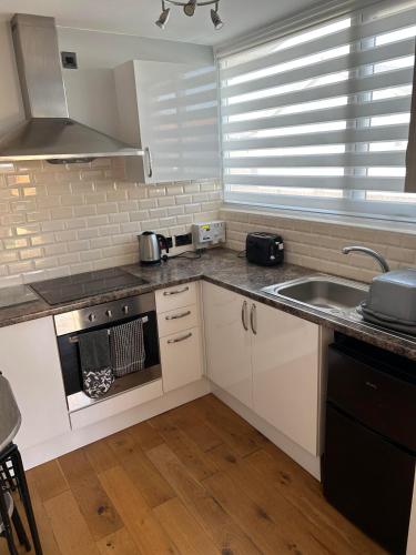 a kitchen with a sink and a stove top oven at Modern One Bedroom Chalet with Central Heating in Bridlington