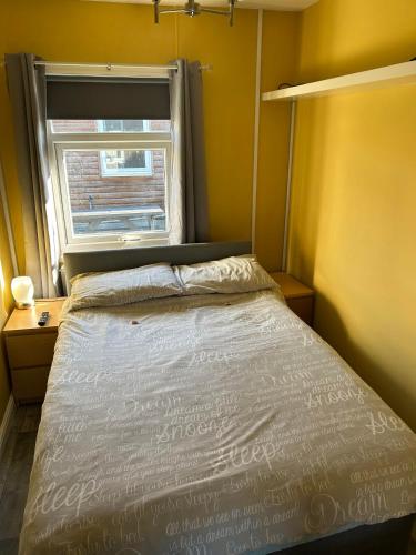 a small bedroom with a bed and a window at Modern One Bedroom Chalet with Central Heating in Bridlington