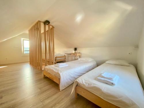 2 łóżka pojedyncze w pokoju z drewnianą podłogą w obiekcie Domek Aurory - Karkonosze w mieście Jeżów Sudecki