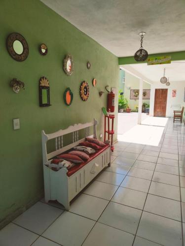 a bedroom with a bed and a green wall at Aquarela Suítes in Piúma