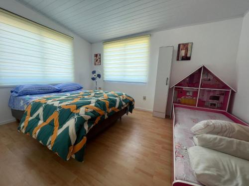 - une chambre avec un lit et une couette colorée dans l'établissement Casa shalet piriapolis 6 personas, à Bella Vista
