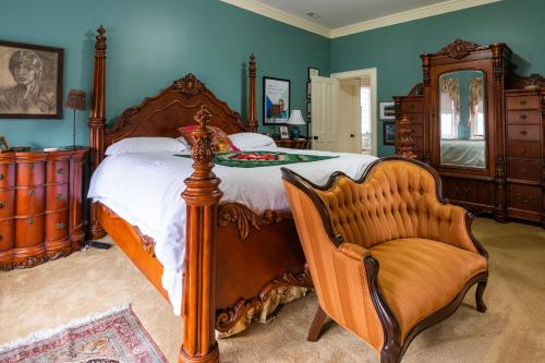 um quarto com uma cama grande e uma cadeira em Exquisite Victorian em Springfield