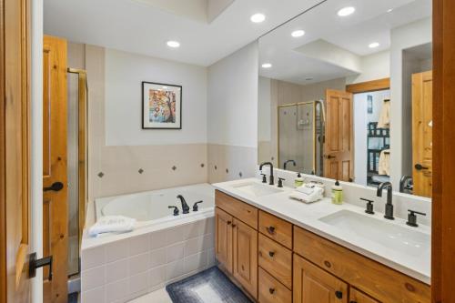 a bathroom with two sinks and a tub and a shower at The Ski Lodge, Unit 306 in Edwards