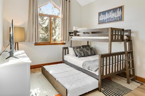 a bedroom with two bunk beds and a television at The Ski Lodge, Unit 306 in Edwards
