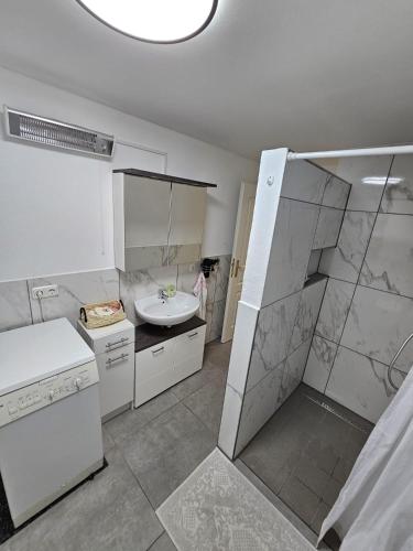 a large white bathroom with a sink and a shower at Ferienwohnung Erna in Marktoberdorf
