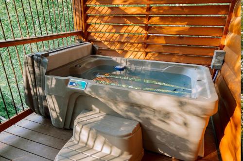 a large bath tub sitting next to a fence at Cricket Hill Treehouse B by Amish Country Lodging in Millersburg