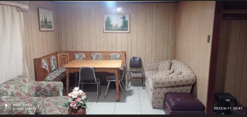 um quarto com uma mesa e cadeiras e um sofá em CASA ISLA MOTA em Valdivia