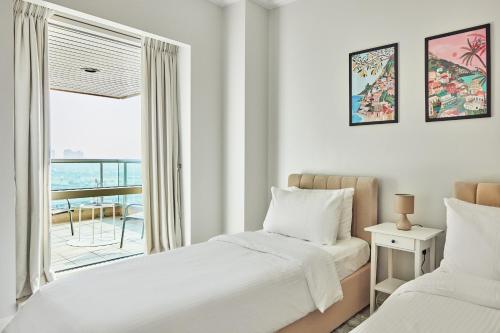 a bedroom with two beds and a window at Luxury Dubai Marina Views On Marina Walk Waterfront 3 Bed Property in Dubai