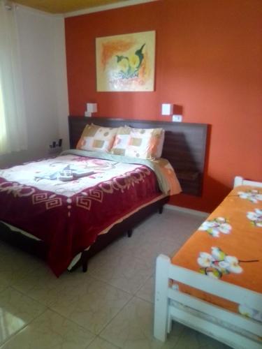 a bedroom with a bed with a red wall at Pousada Pica Pau in Urubici