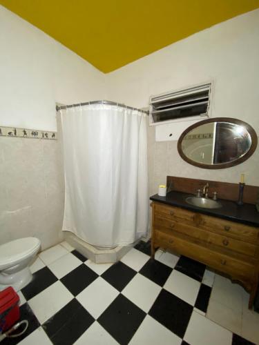 uma casa de banho com um WC, um lavatório e um espelho. em Cerro Chico em Villa Cura Brochero