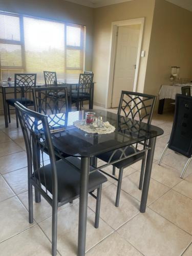 a dining room with a black table and chairs at Chamo bed and breakfast in East London