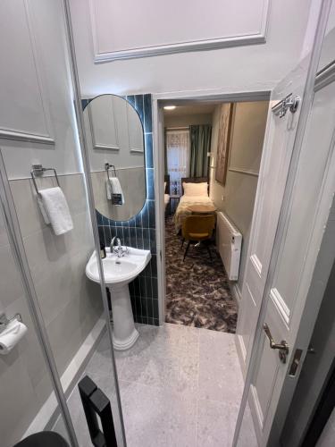 Baño pequeño con lavabo y espejo en Topper's Rooms Guest Accommodation, en Carrick on Shannon