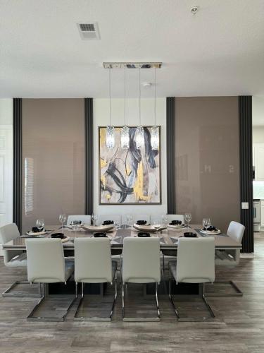 a dining room with a table and chairs and a painting at The Epic Milan Penthouse Orlando in Orlando