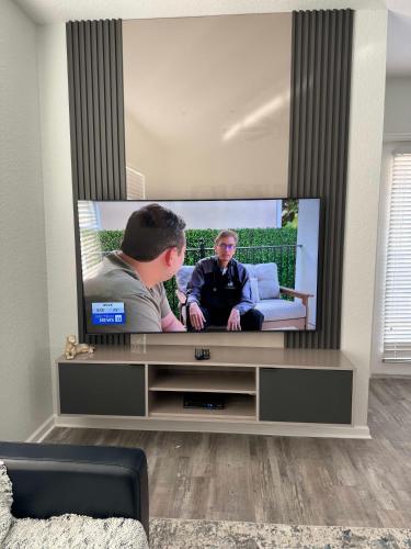 a flat screen tv in a living room at The Epic Milan Penthouse Orlando in Orlando