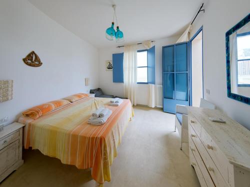 1 dormitorio con 1 cama con manta naranja y amarilla en La Naca sul Mare - Suite, en Nardò