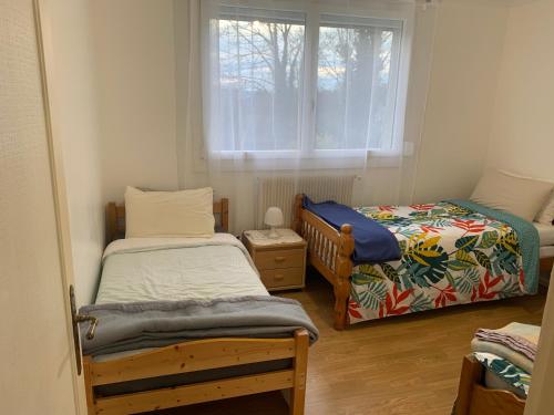 1 Schlafzimmer mit 2 Einzelbetten und einem Fenster in der Unterkunft Maison de 6 à 8 personnes in Faches-Thumesnil
