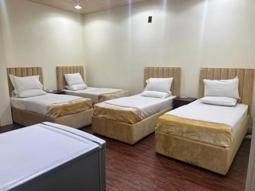 a room with three beds and a tv at Sport Hotel in Dubai