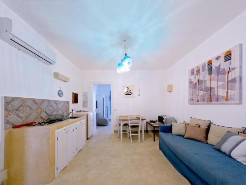een woonkamer met een blauwe bank en een tafel bij La Naca sul Mare - Suite in Nardò