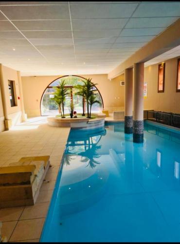 - une piscine avec une fontaine dans un bâtiment dans l'établissement Appartements avec PISCINE INTÉRIEURE SAUNA Parking Étage 1 au Centre du Village dans Résidence Cami Réal, à Saint-Lary-Soulan