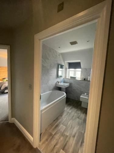a bathroom with a tub and a sink and a toilet at Spacious Apartment NEC BHX in Solihull