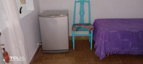 una habitación con un cubo de basura y una silla azul en Hospedaje LA LUCIA en Almafuerte