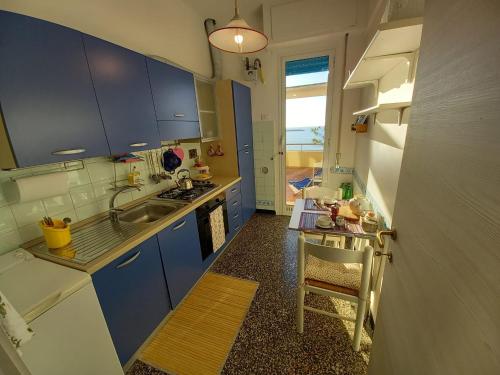 a kitchen with blue cabinets and a sink and a table at Attico Vista Mare Sestri Levante in Sestri Levante
