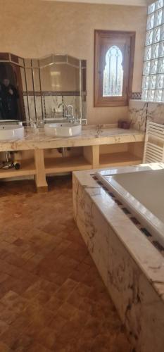 duża łazienka z wanną i umywalką w obiekcie VILLA ROSERAIE w Marakeszu