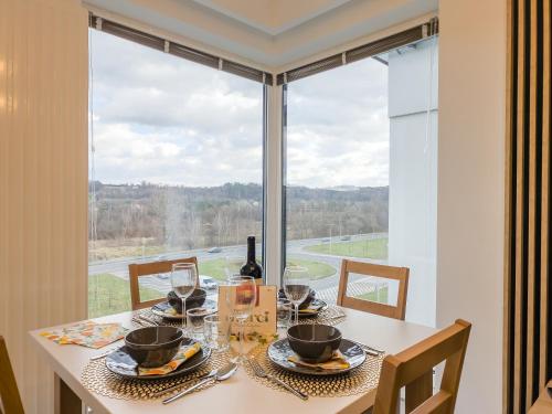 a dining room table with a view of a window at Beskid Apartamenty in Nowy Sącz
