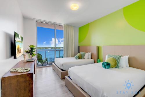 a hotel room with two beds and a balcony at Costa Hollywood Beach in Hollywood