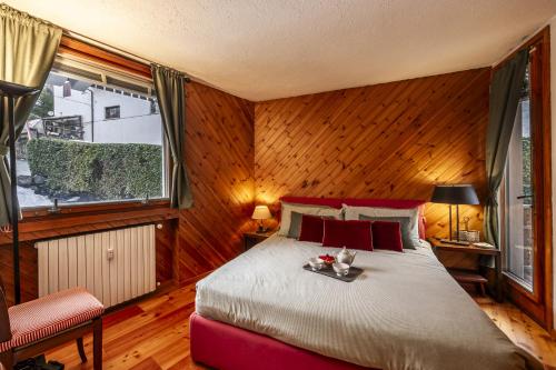 een slaapkamer met een bed in een kamer met houten wanden bij Maison Simone - wifi parking and mountain view in Courmayeur