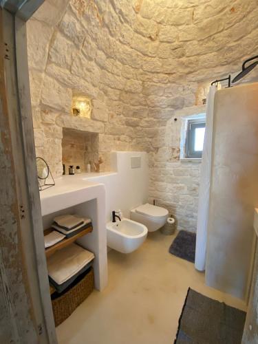 een badkamer met een witte wastafel en een toilet bij TRULLI TERRA DI MEZZO in Cisternino