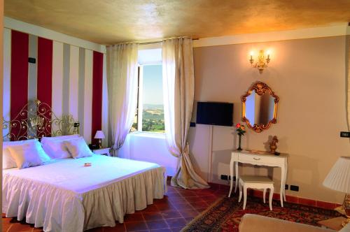 um quarto com uma cama, uma janela e um espelho em La Foresteria del Castello - Wellness Hotel in Dimora Storica em CastellʼAlfero