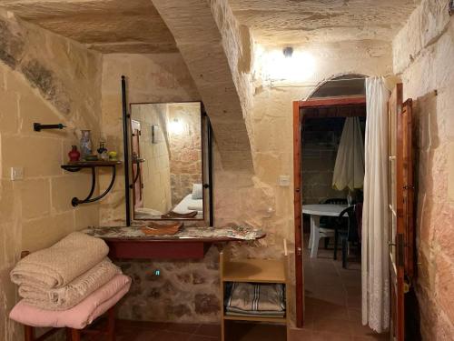 een badkamer met een spiegel en een wastafel in de kamer bij 400YR Farmhouse in Xaghra Gozo - Separate Rooms in Xagħra