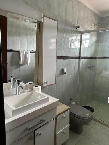 a bathroom with a sink and a toilet and a mirror at Hotel Costa Dalpiaz in Torres