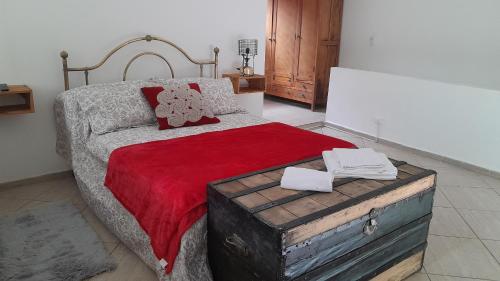 een slaapkamer met een groot bed en een rode deken bij El Rinconcito de la Selva in La Calera