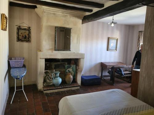 une pièce avec une cheminée et une personne debout dans une pièce dans l'établissement La Maison du Donjon - Gites de 8 personnes, parking privé avec jardin terrasse, à Loches